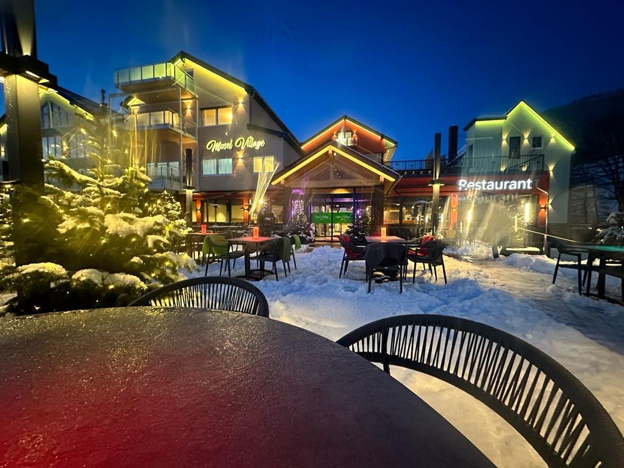 Festlich beleuchtetes Mosel Village Resort mit Restaurant am verschneiten Silvesterabend