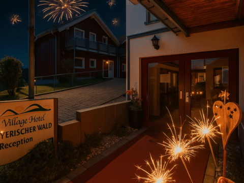 Eingang des Village Hotel Bayerischer Wald bei Nacht mit Feuerwerk und Wunderkerzen