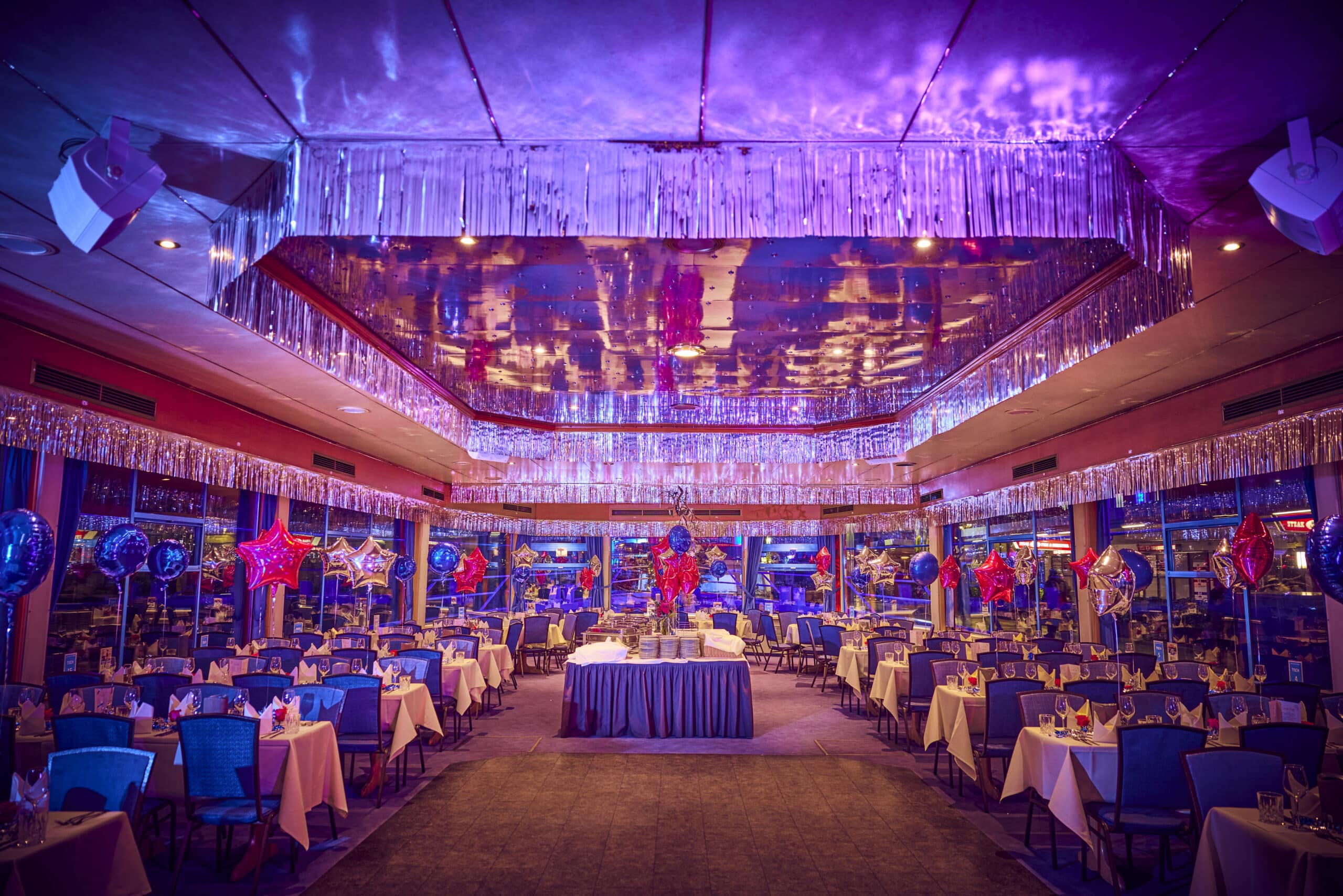 Festlich dekorierter Innenraum der MS Hamburg für die Silvesterfeier mit gedeckten Tischen und Ballondekoration