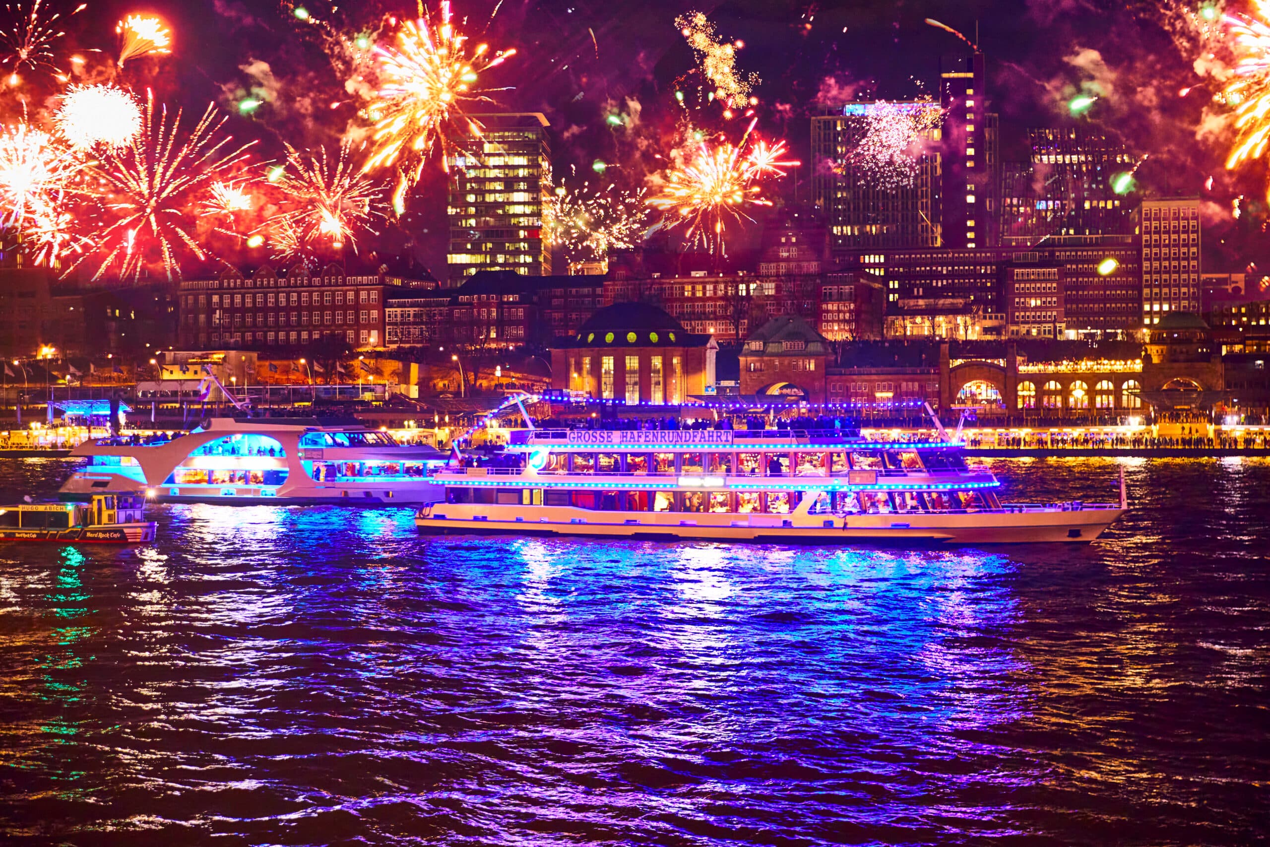 MS Hanse Star auf der Elbe mit buntem Silvesterfeuerwerk vor den Hamburger Landungsbrücken