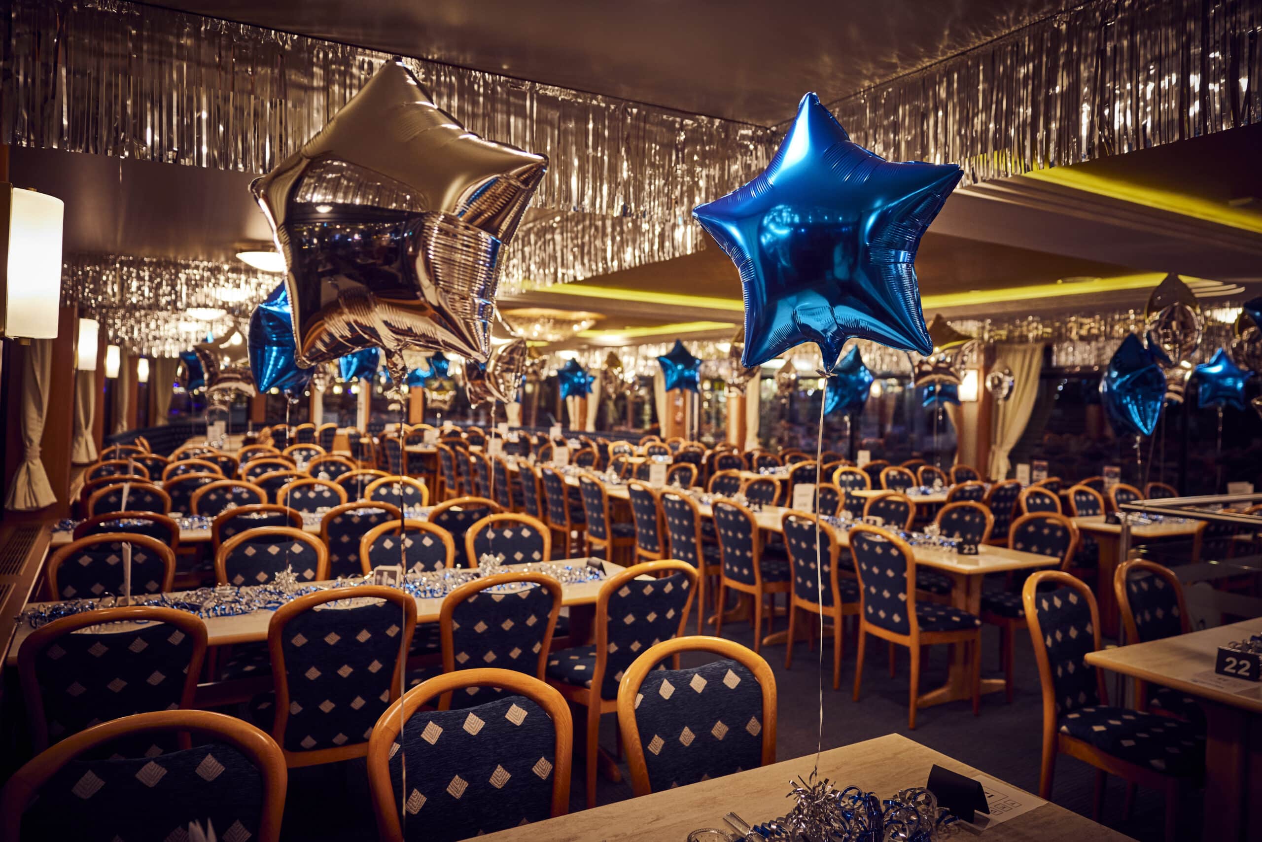 Stimmungsvoll dekorierter Speisesaal auf der MS Hanse Star mit blauen und silbernen Stern-Ballons zu Silvester