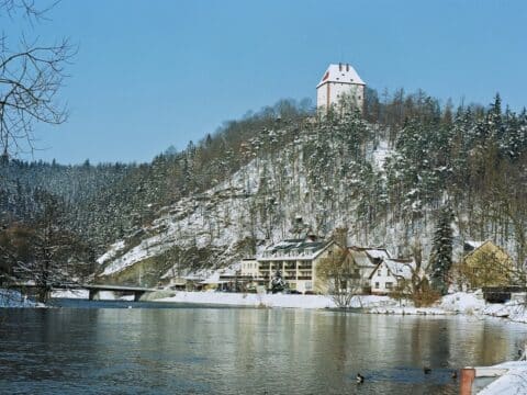 Blick auf das Hotel am Schlossberg Ziegenrück im Schnee mit Burg