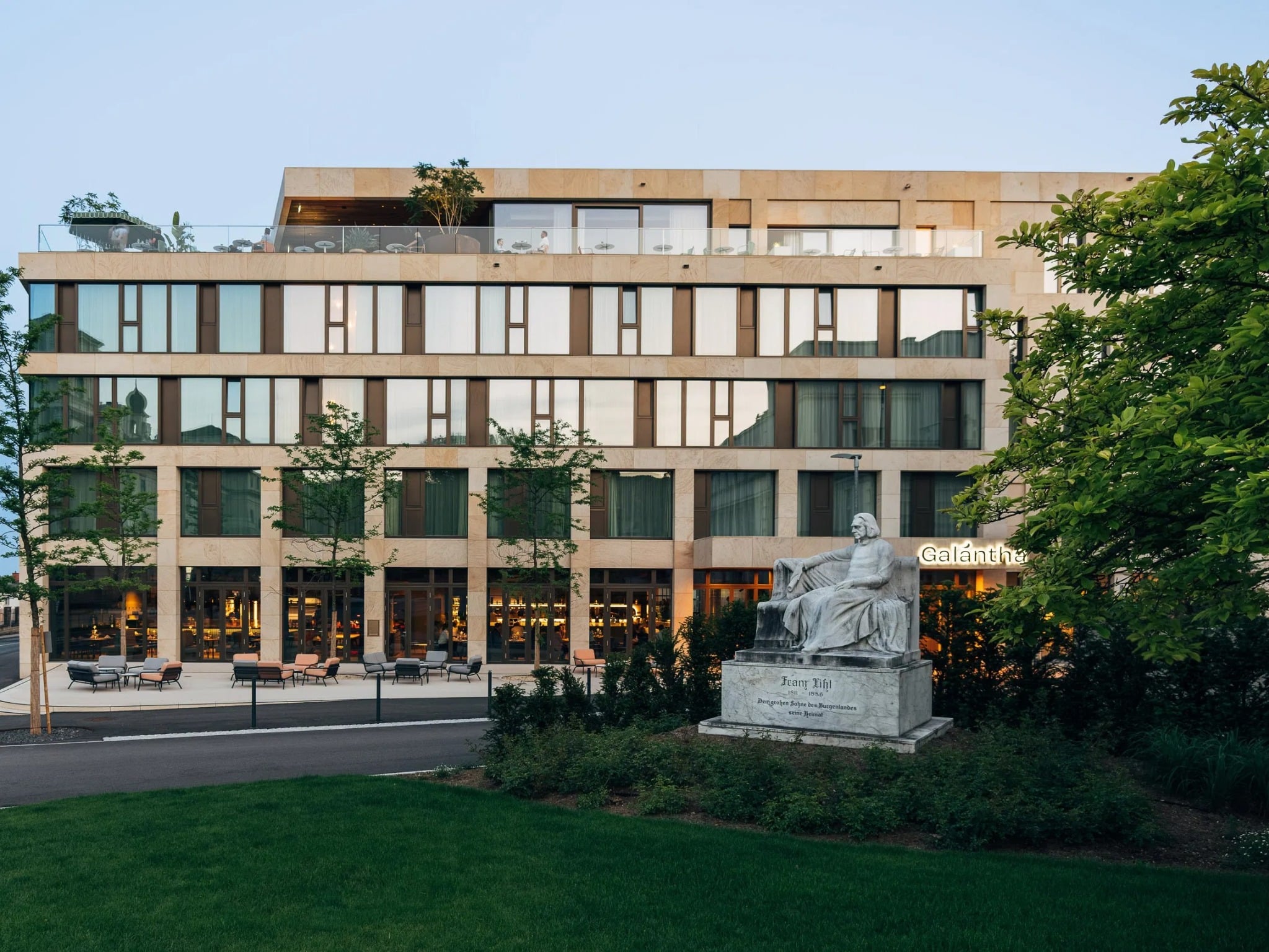 Außenansicht des Hotels Galántha in Eisenstadt mit Statue im Vordergrund, ideal für Silvester 2025
