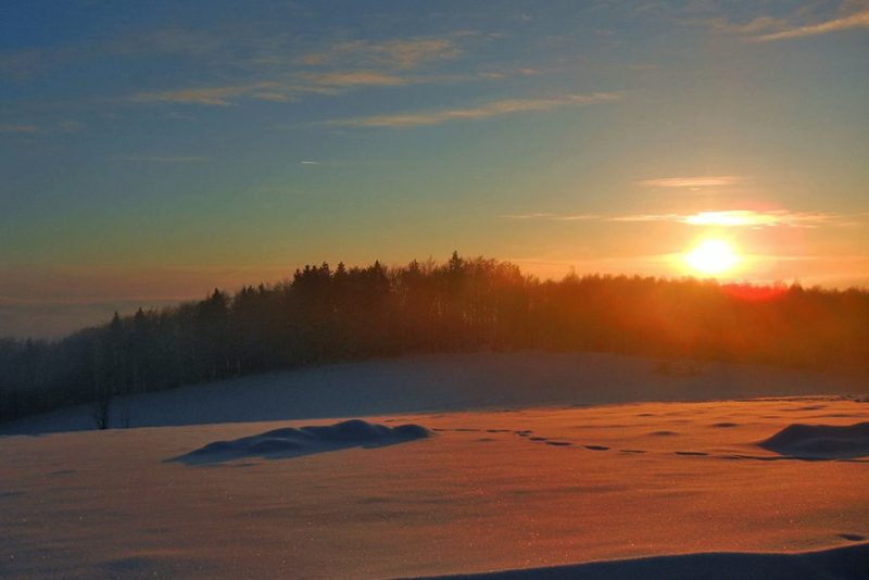 Sonnenuntergang über verschneiter Landschaft zu Silvester im Landgut Stetter